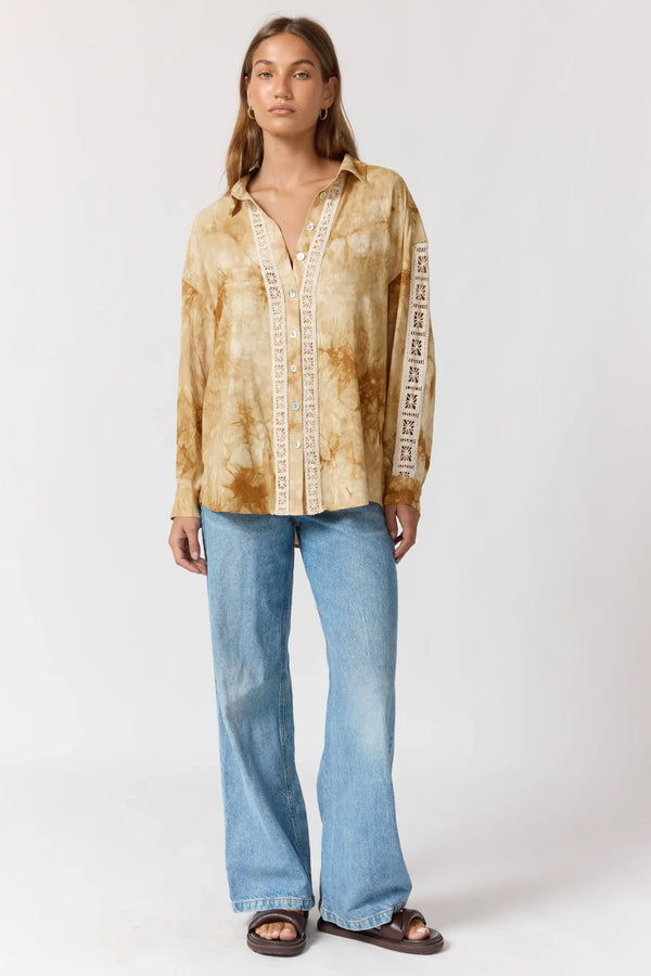 Woman wearing a tie-dye shirt and blue jeans on a white background