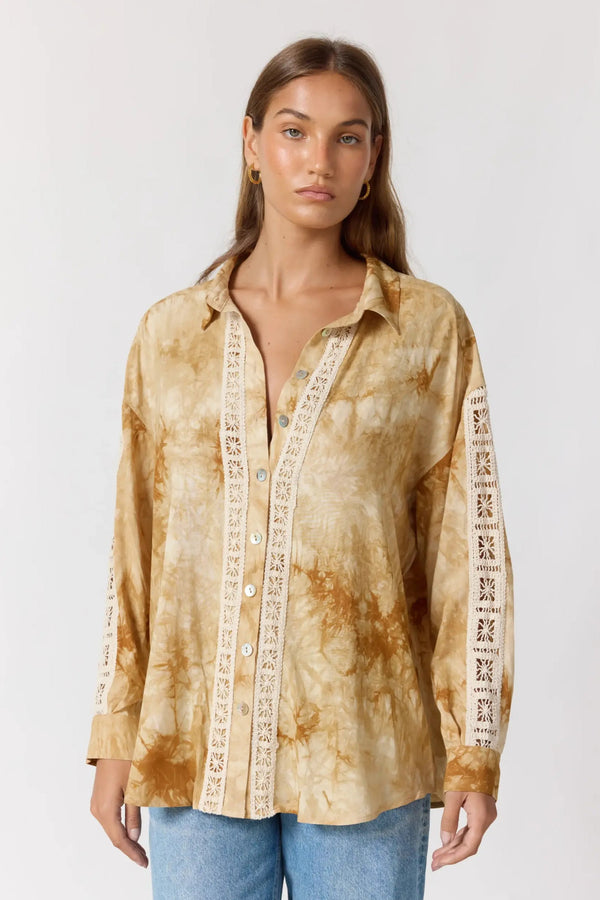 Woman wearing a tie-dye shirt with lace details on a white background