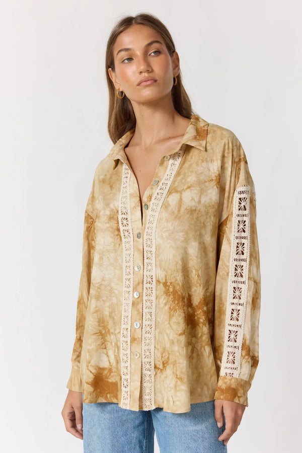 Woman wearing a tie-dye shirt with graphic sleeves on a white background