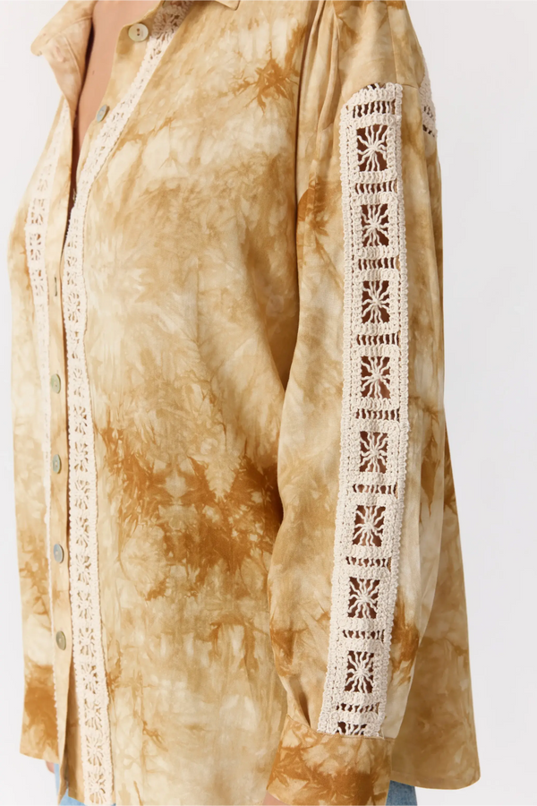 Tie-dye shirt with lace detailing on a plain background