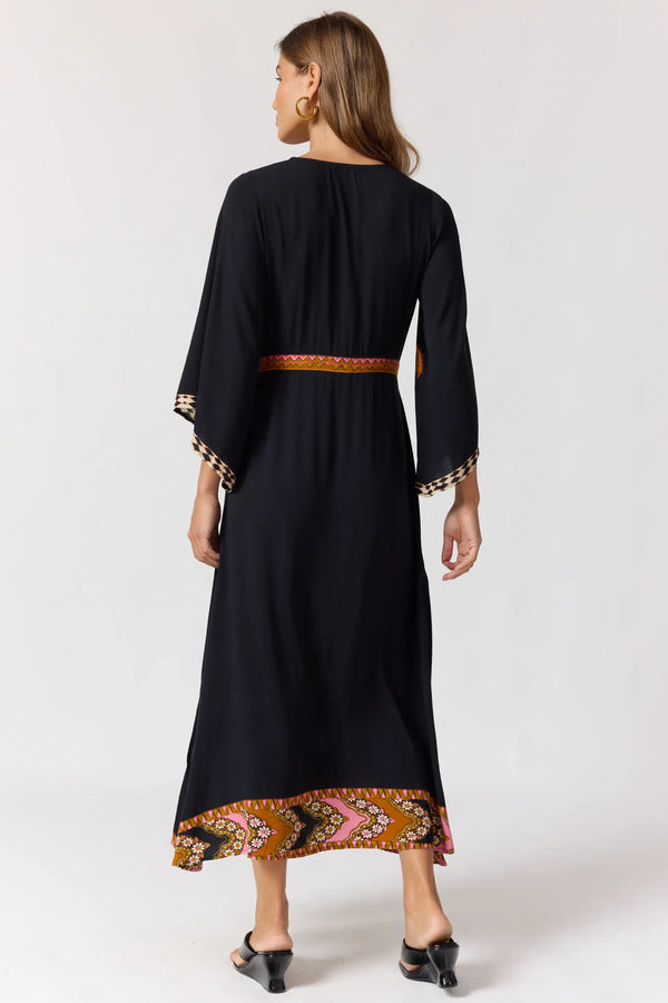 Black dress with patterned hem and cuffs on a white background