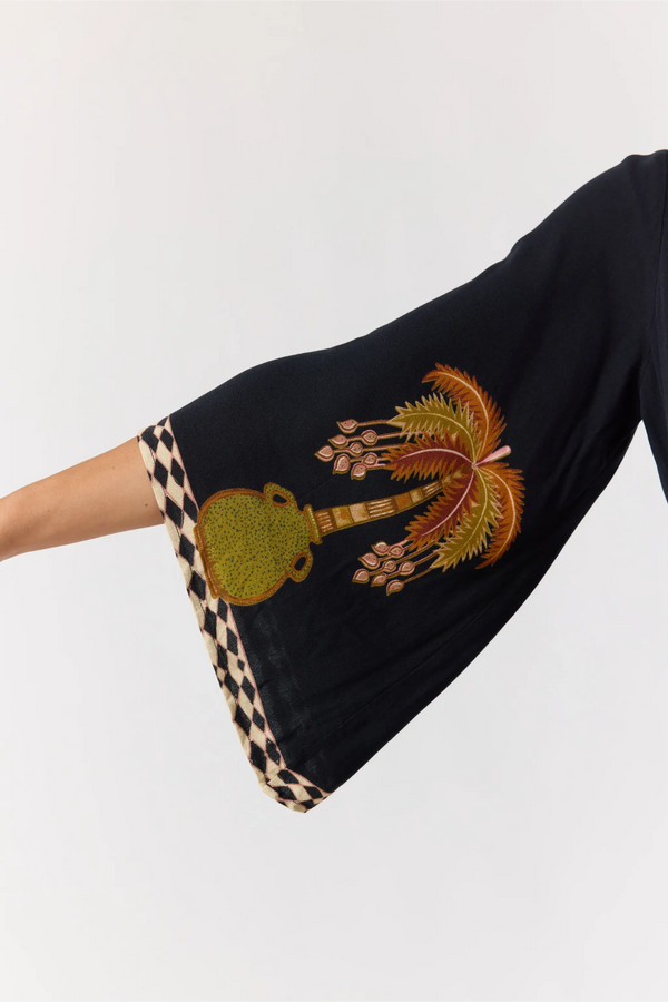 Black garment with intricate embroidery on a white background