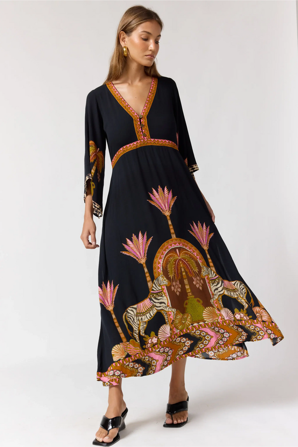 Woman wearing a black dress with colorful animal print on a white background