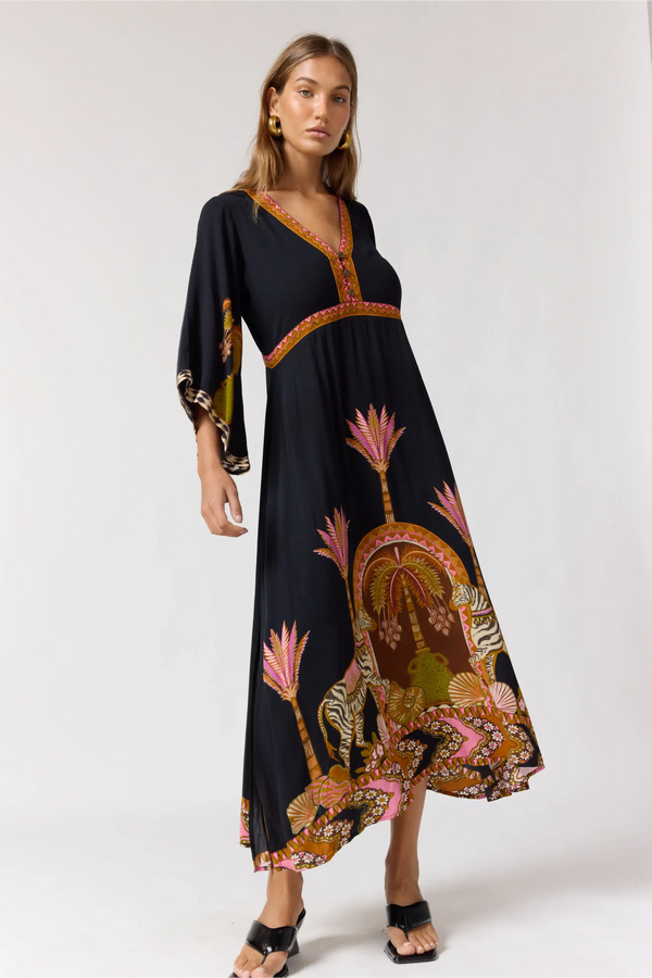 Woman wearing a black dress with colorful floral patterns on a white background