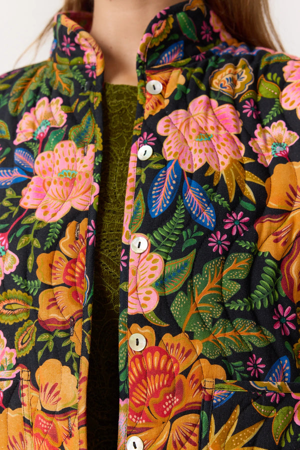 Close-up of a floral patterned garment with vibrant colors on a plain background