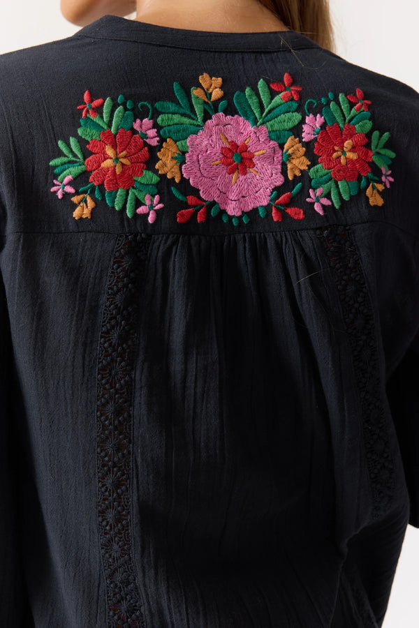 Black garment with colorful floral embroidery on the back