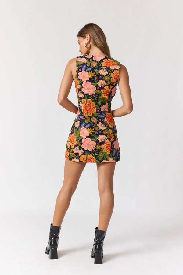 Woman wearing a colorful floral dress on a white background