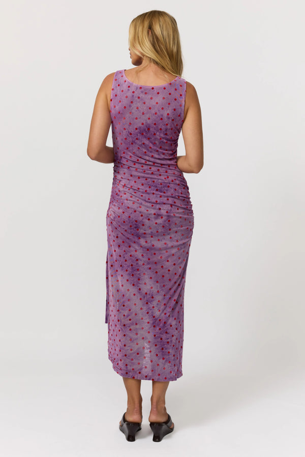 Woman wearing a purple patterned dress on a white background