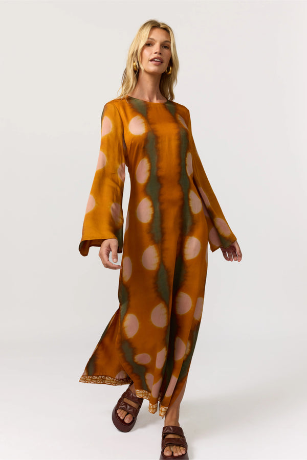 Woman wearing a long, patterned dress on a white background