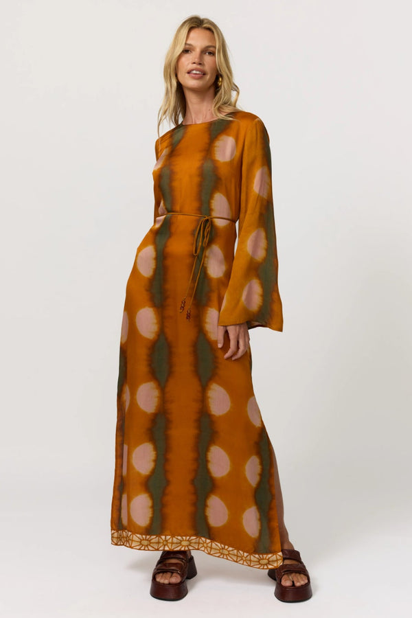 Woman wearing a long, patterned dress on a white background