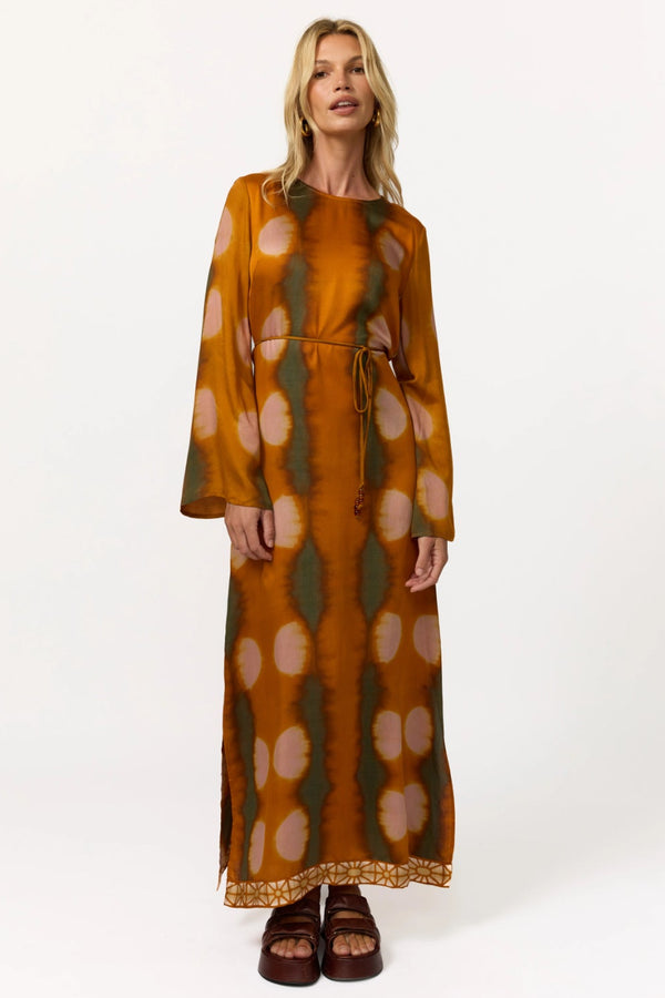 Woman wearing a long, patterned dress on a white background