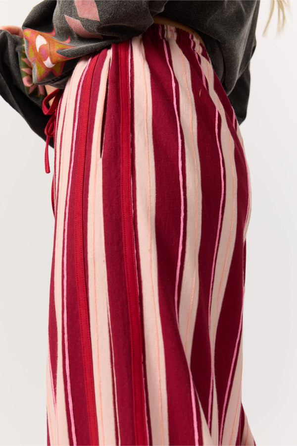 Red and white striped pants worn by a person on a plain background
