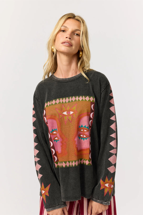Woman wearing a black sweater with colorful abstract design on a white background