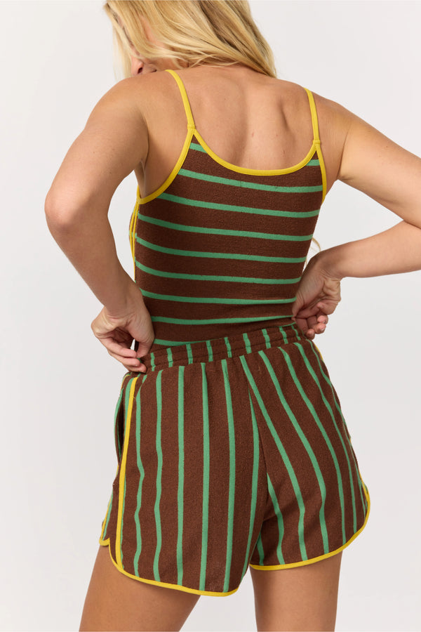 Person wearing a brown and green striped romper with yellow trim on a white background