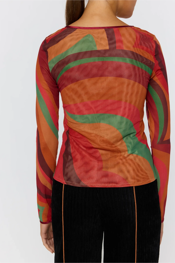 Colorful patterned top worn by a person on a white background