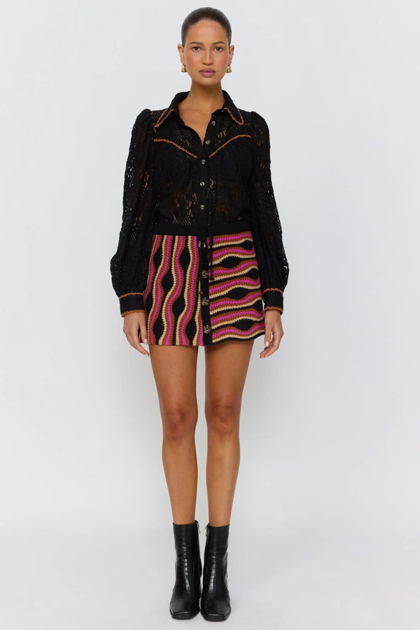 Woman wearing a black jacket and zebra-striped skirt on a white background