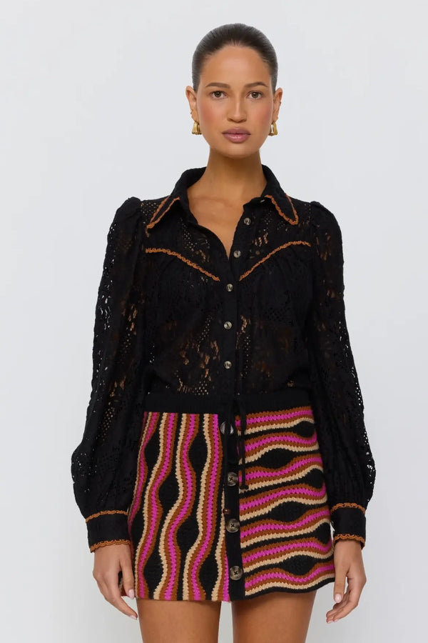 Woman wearing a black jacket and zebra-striped skirt on a white background