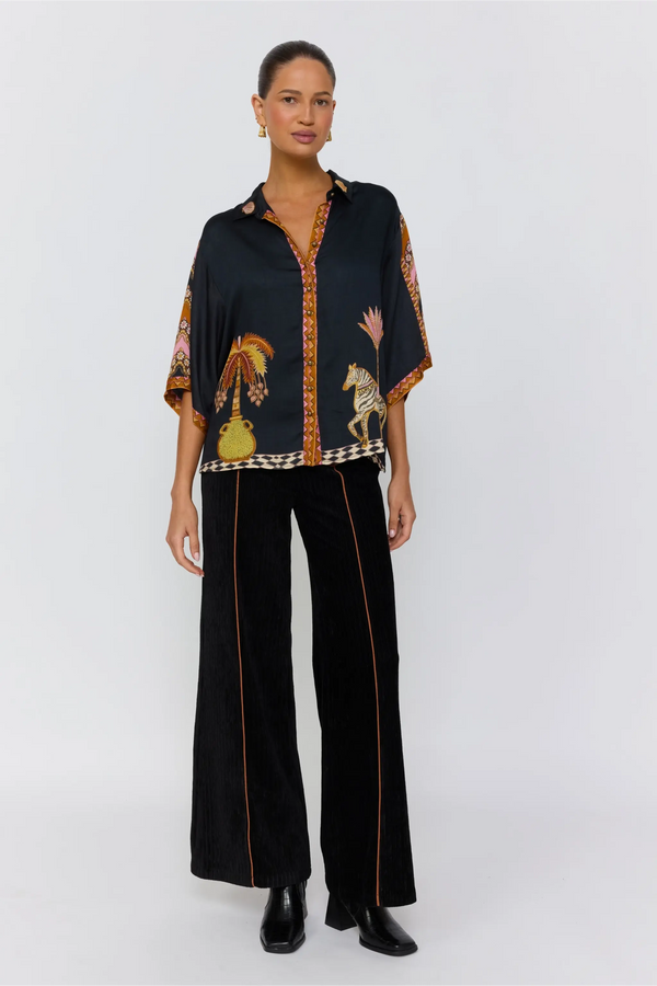 Woman wearing a black outfit with colorful patterns on a white background