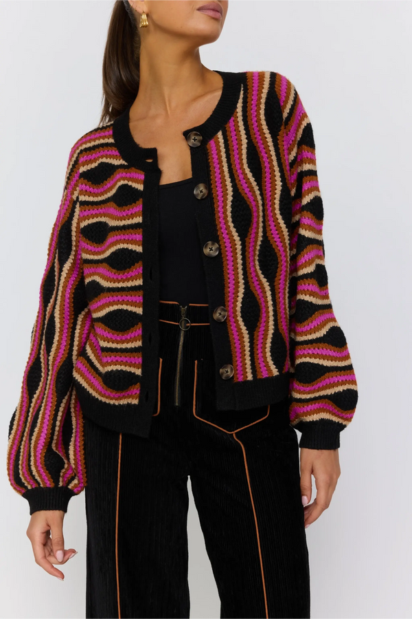 Person wearing a patterned cardigan with a plain background