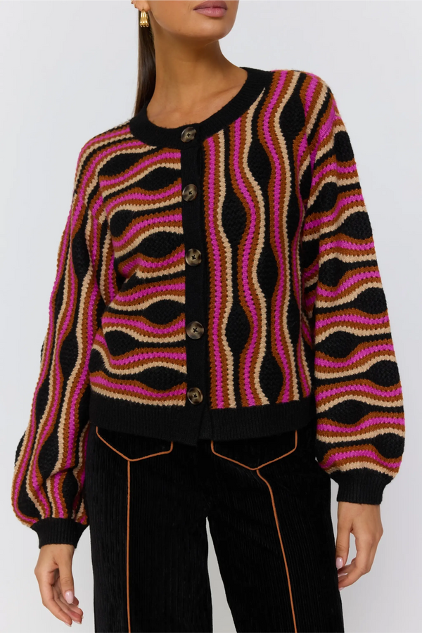 Person wearing a patterned cardigan with a white background