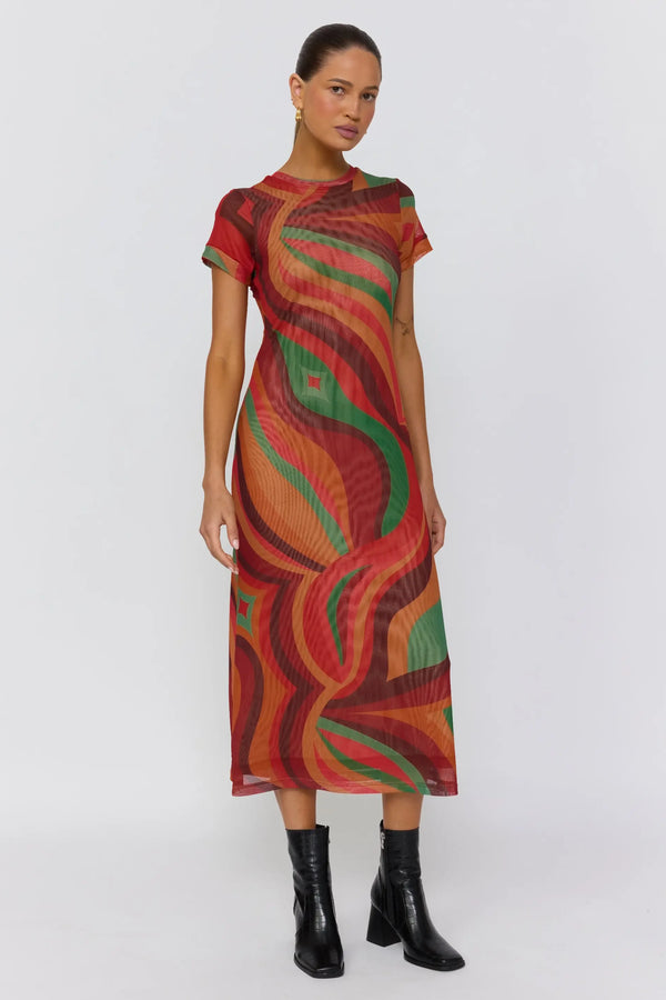 Woman wearing a colorful dress with a pattern on a white background