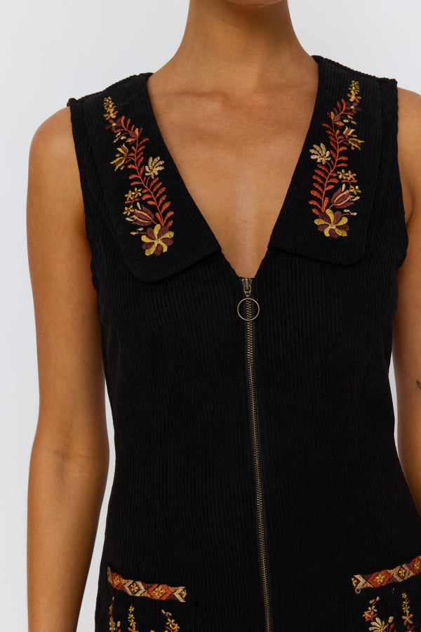 Black sleeveless top with floral embroidery on a white background