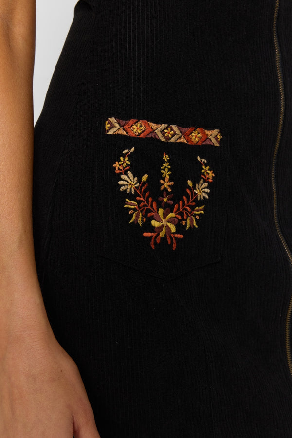 Black garment with floral embroidery on a plain background