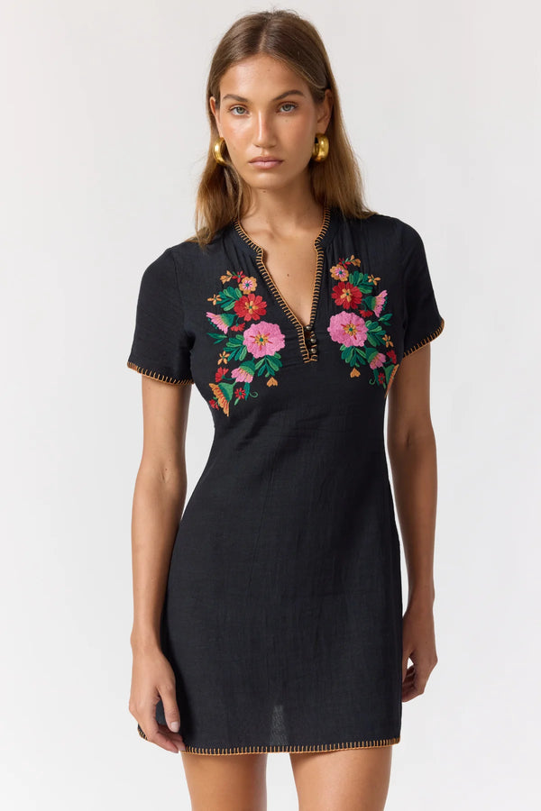 Black dress with colorful floral embroidery on a white background