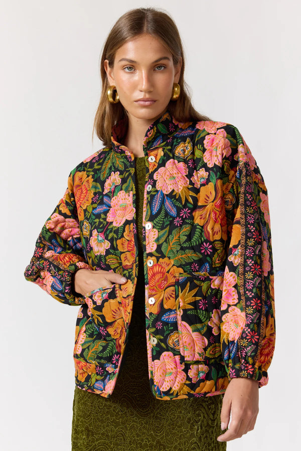 Woman wearing a colorful floral jacket on a white background