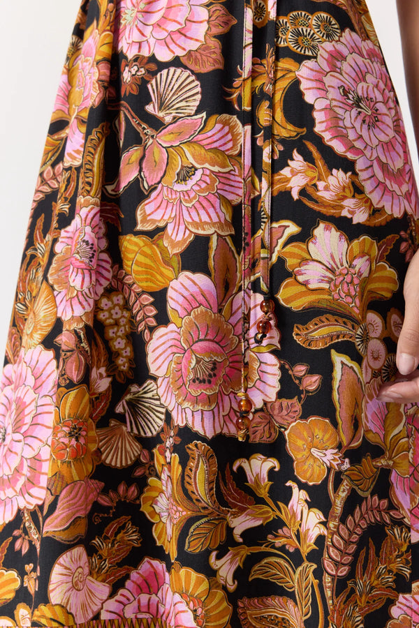 Close-up of a floral patterned fabric with pink, orange, and yellow flowers on a black background.
