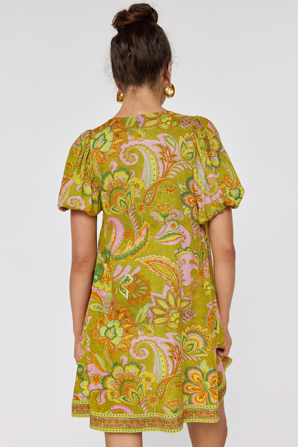 Woman wearing a colorful patterned dress on a white background