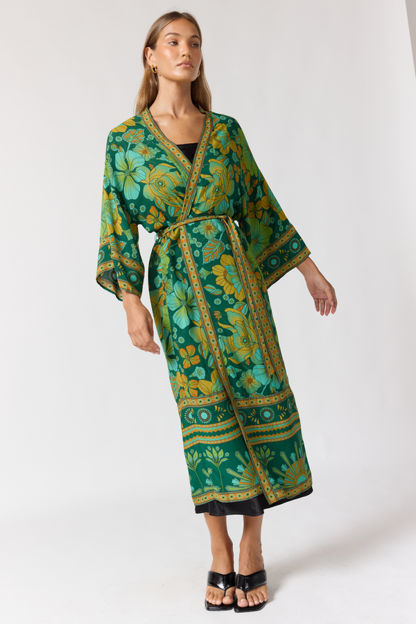 Woman wearing a green floral patterned robe on a white background