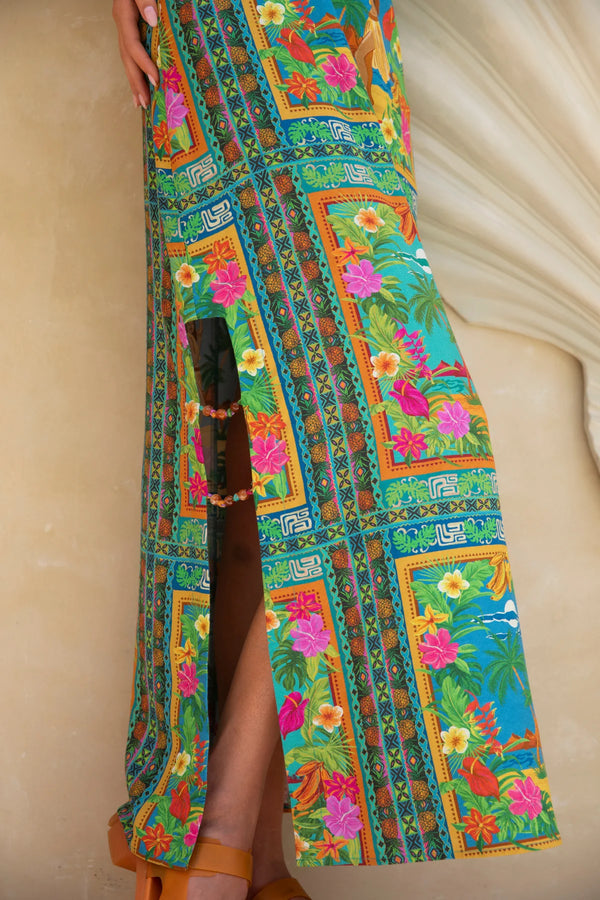 Colorful patterned dress with a high slit on a plain background