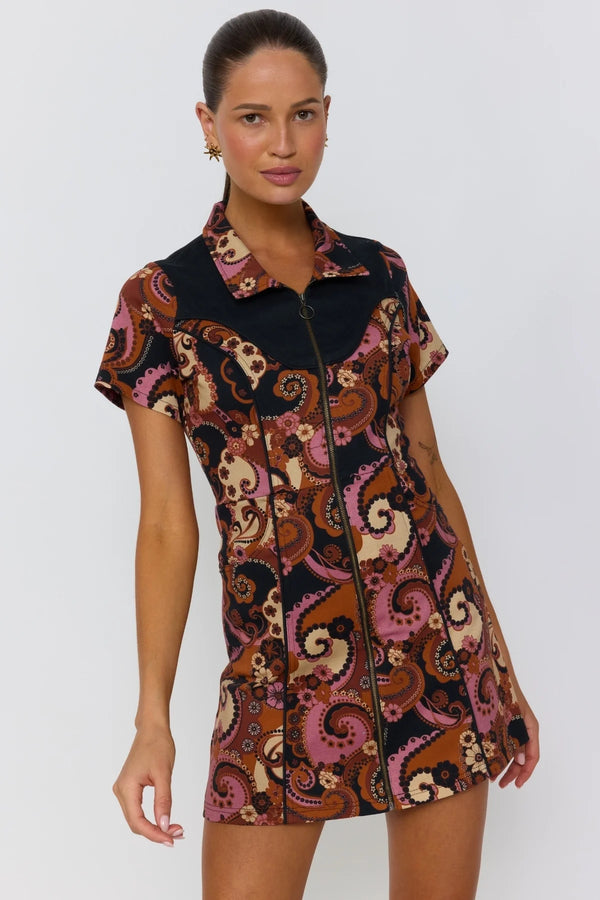 Woman wearing a patterned dress on a plain background
