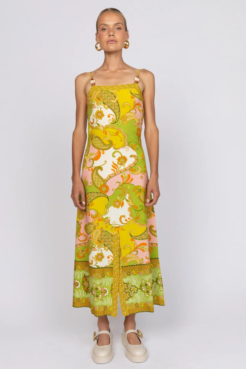 Model wearing a colorful floral dress on a white background