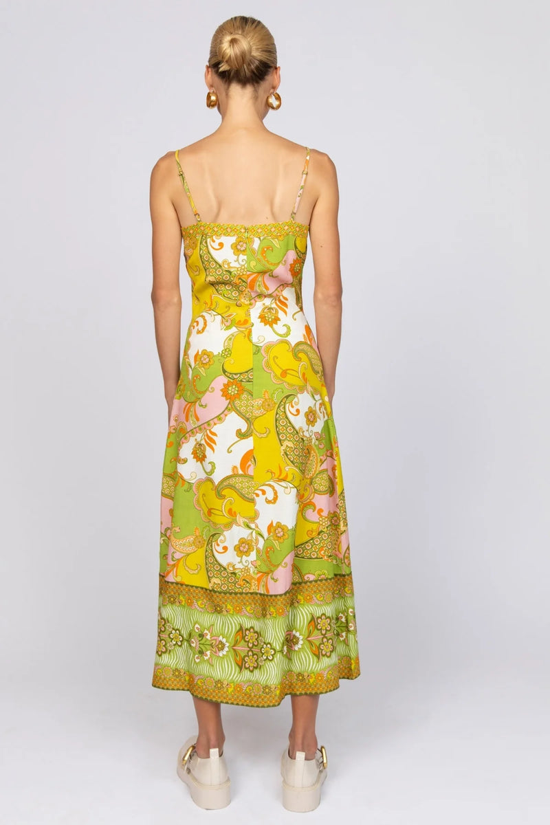 Model wearing a colorful floral dress on a white background