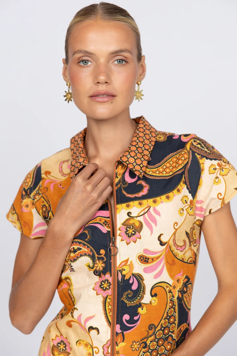 Woman wearing a colorful patterned dress on a light gray background