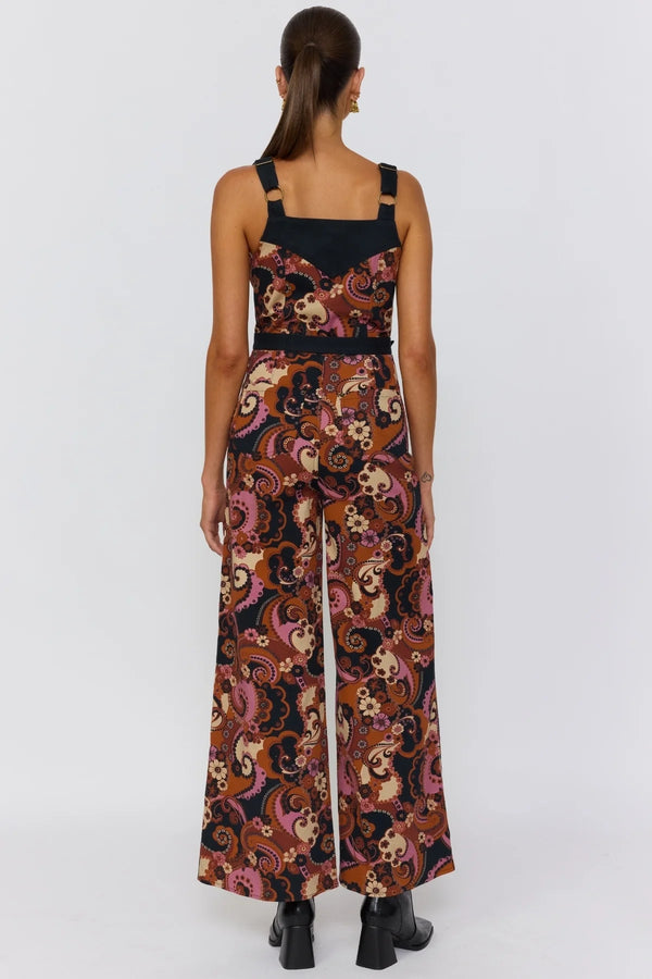Woman wearing a patterned jumpsuit on a white background