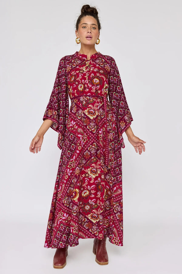 Woman wearing a red patterned dress on a white background