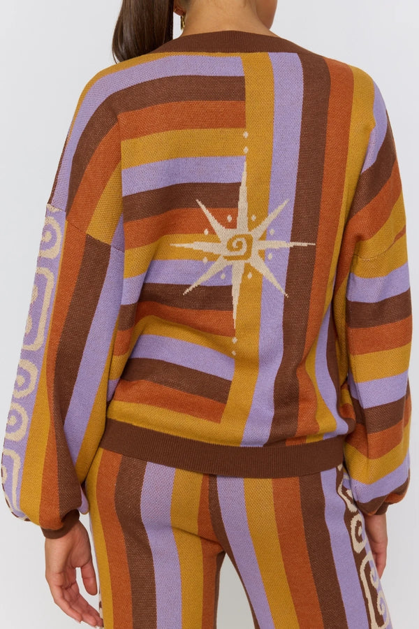 Colorful striped sweater with a star design on a plain background