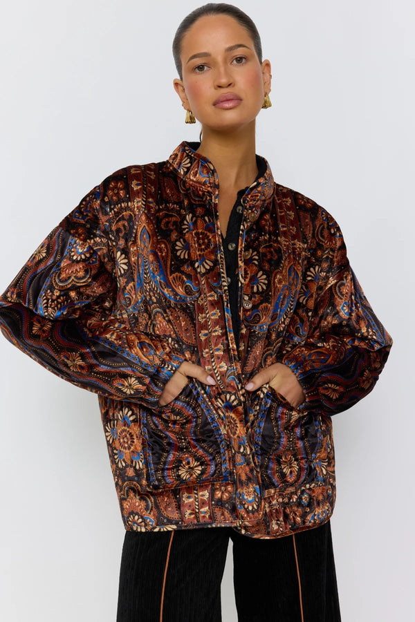 Woman wearing a patterned jacket against a white background