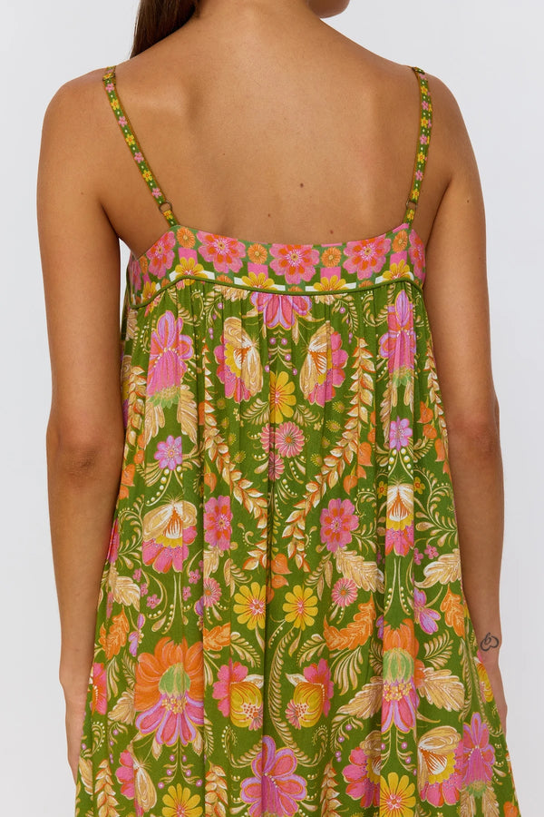 Woman wearing a colorful floral dress with green background