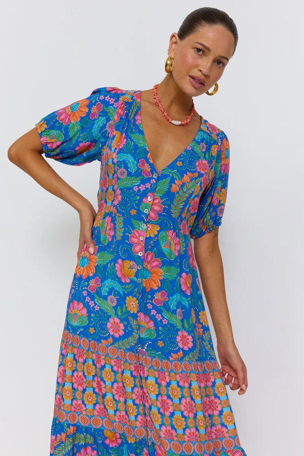 Woman wearing a colorful floral dress against a white background