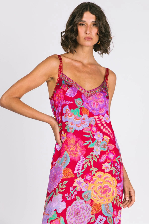 Woman wearing a vibrant floral dress on a white background