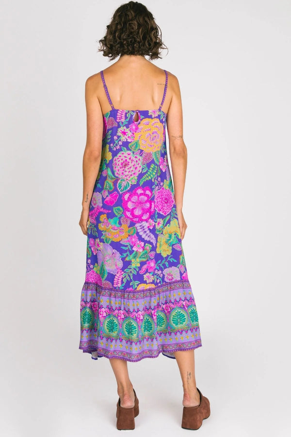 Woman wearing a colorful floral dress on a white background