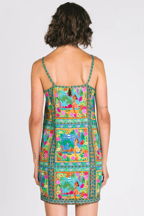 Woman wearing a colorful dress with a pattern on a plain background