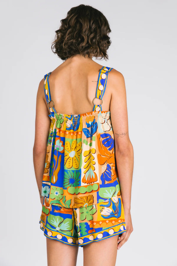 Woman wearing a colorful floral dress with a plain background