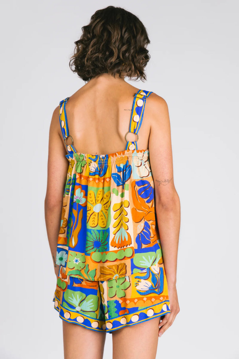 Woman wearing a colorful floral dress with a plain background