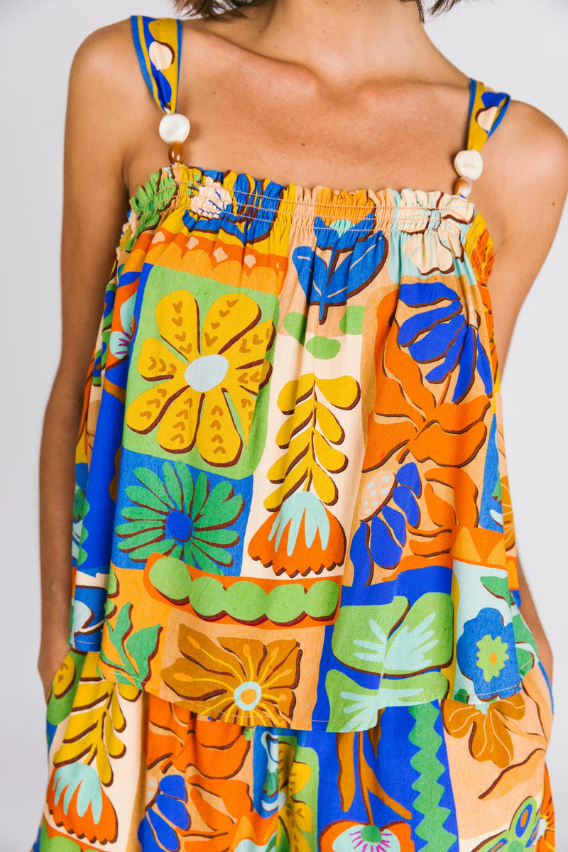 Colorful floral top with orange, blue, and green patterns on a plain background
