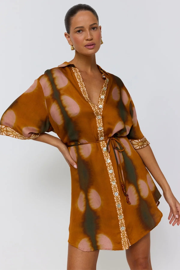 Woman wearing a patterned dress with a plain background